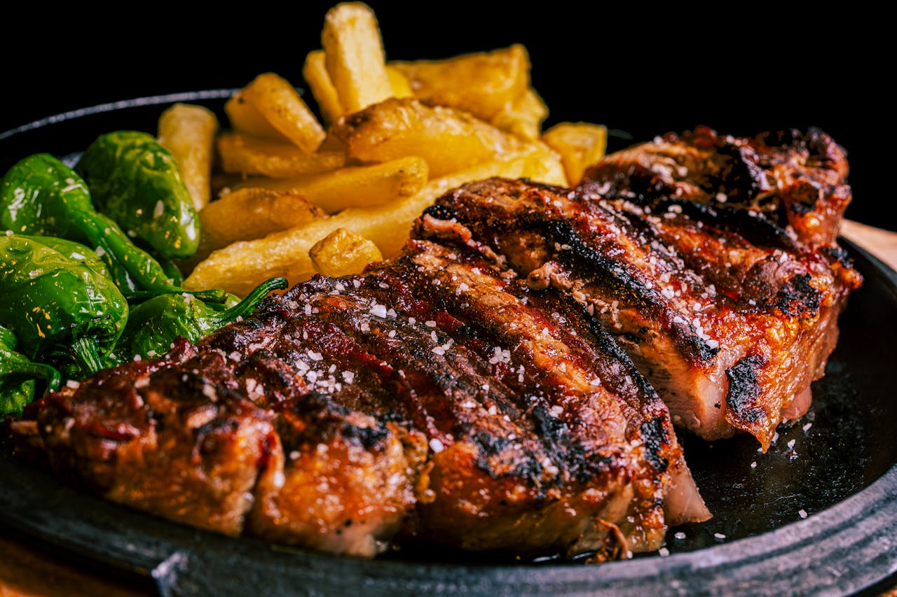 Succulent grilled steak served with crispy fries and roasted green peppers.